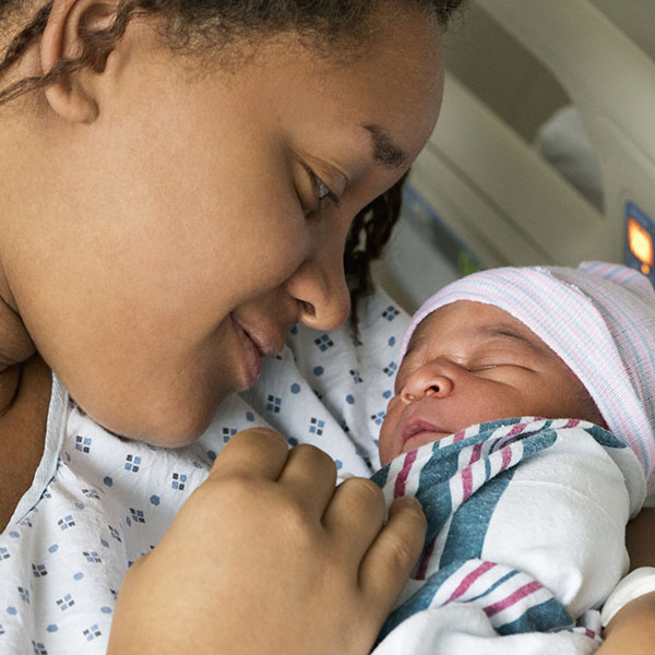 Woman smiling at newborn