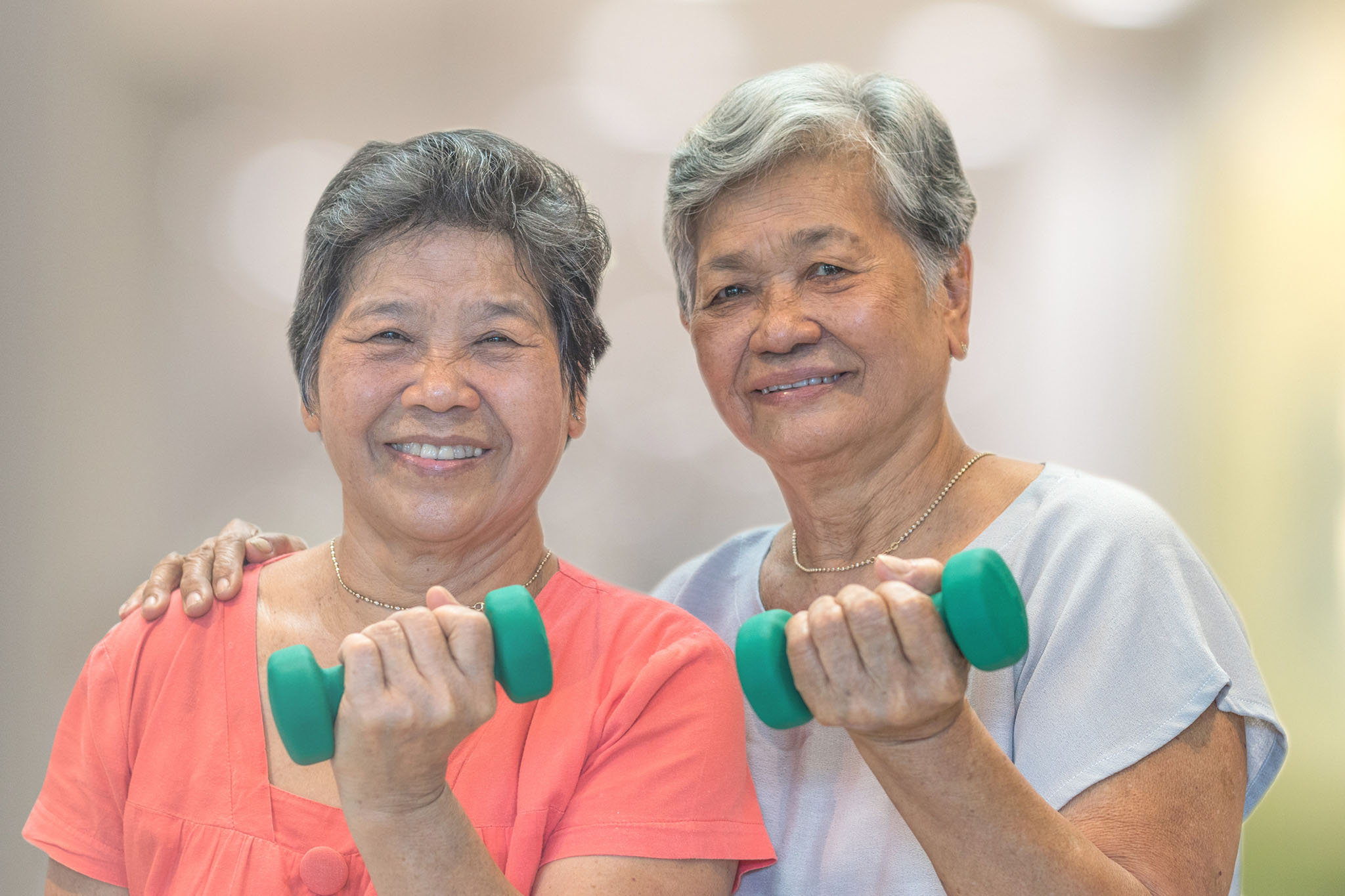 two older woman holding free weights